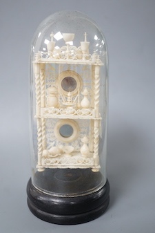 A Victorian ivory model of objects on a whatnot, under a glass dome 16cm